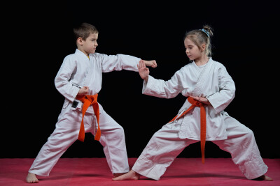 little child boy in a white karate kimono training. Full length portrait
